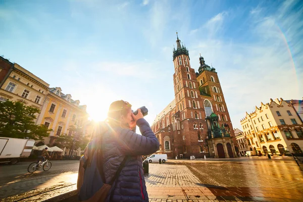 波兰克拉科夫日出时分 年轻时尚的女性游客在市场广场拍摄著名的圣玛丽大教堂的照片 — 图库照片