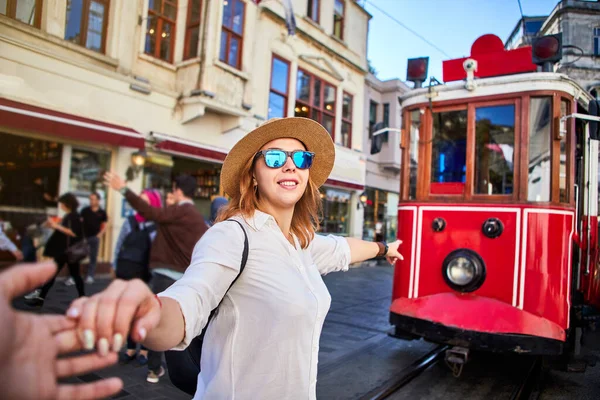 在土耳其伊斯坦布尔碧昂鲁的Istiklal大街上 戴着帽子的漂亮女游客在塔克西姆电车前摆姿势 — 图库照片