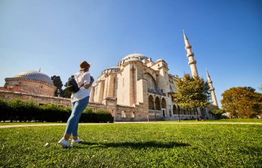 Şapkalı mutlu çekici kadın turist, İstanbul 'daki Süleyman Camii' nin arka planında poz veriyor. Din ve seyahat kavramı.