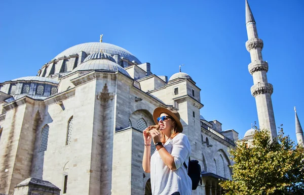 Ευτυχισμένη Ελκυστική Γυναίκα Τουρίστρια Καπέλο Τρώει Σιμίτσι Ένα Στρογγυλό Κουλούρι — Φωτογραφία Αρχείου