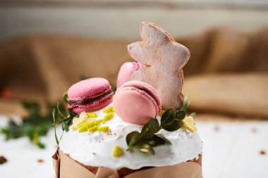 Beyaz ahşap arka planda Paskalya Tavşanı pastası geleneksel Kulich, Paska kutlamaya hazır.