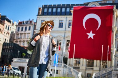 İstanbul 'daki Beyoğlu Belediye Binası' nda Türk bayrağının arka planında duran çekici genç bayan turist