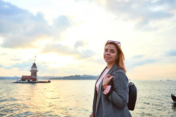 女游客看着日落 看到的是Maiden塔 土耳其语 Kiz Kulesi 也就是土耳其伊斯坦布尔的标志 Leander塔 — 图库照片