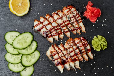 Füme yılan balığı dilimlenmiş fileto taze salatalık, zencefil turşusu ve slate tabakta wasabi.