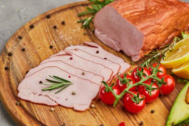 Baharatlı jambon, marul, avokado ve ahşap kesim tahtasında domates. Eski et tabağı, taze prosciutto