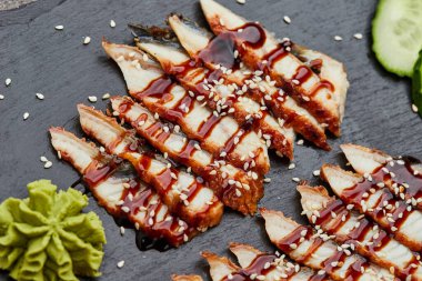 Füme yılan balığı dilimlenmiş fileto taze salatalık, zencefil turşusu ve slate tabakta wasabi.