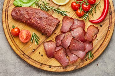 Baharat, marul, limon ve domatesle süslenmiş tahta üzerinde Ermeni basturma veya Pastirma. Et tütsülenmiş kurutulmuş et, bira kadar iyidir.