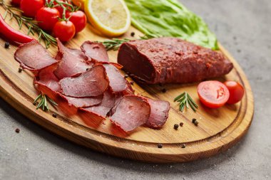 Baharat, marul, limon ve domatesle süslenmiş tahta üzerinde Ermeni basturma veya Pastirma. Et tütsülenmiş kurutulmuş et, bira kadar iyidir.