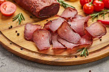 Baharat, marul, limon ve domatesle süslenmiş tahta üzerinde Ermeni basturma veya Pastirma. Et tütsülenmiş kurutulmuş et, bira kadar iyidir.