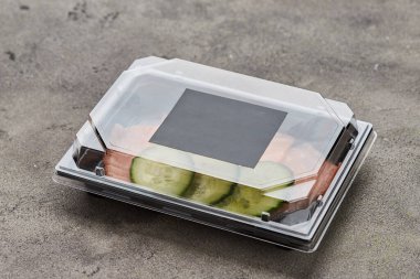 Plastik kutuda salatalıklı taze dilimlenmiş somon filetosu teslimata hazır. Vahşi Atlantik Balığı. Boşluğu kopyala