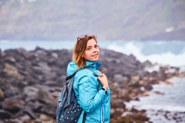 Sırt çantalı kadın turist rıhtımda durup Puerto de la Cruz 'da okyanusu izliyor, Kanarya Adaları, İspanya