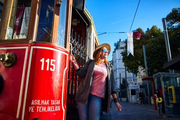 2019年10月11日 土耳其伊斯坦布尔 年轻美丽的女孩在碧昂鲁的怀旧传统红色电车附近观光 高西姆广场至铁路隧道之间的Istiklal街设有缆车线 — 图库照片