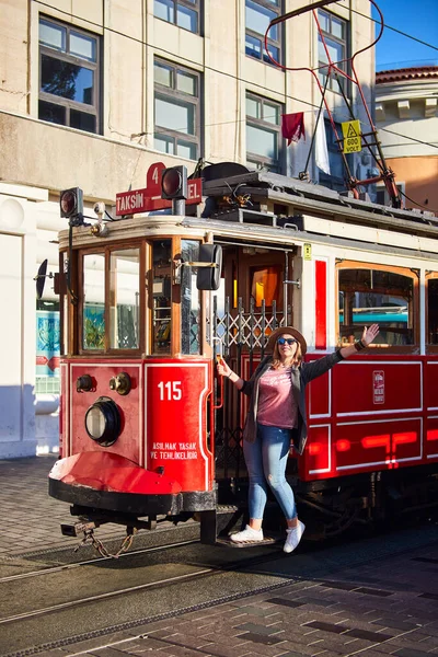 2019年10月11日 土耳其伊斯坦布尔 年轻美丽的女孩在碧昂鲁的怀旧传统红色电车附近观光 高西姆广场至铁路隧道之间的Istiklal街设有缆车线 — 图库照片