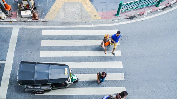 A multidão de pessoas de cidade ocupada vai passagem pedestre que cruza na estrada de tráfego com o mini carro de Tuktuk. Banguecoque, Tailândia (foto aérea, vista superior ) — Fotografia de Stock