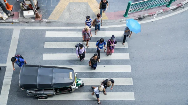 Bangkok, Thajsko - 24. října 2016: Rušné město lidé dav jít projít přechod pro chodce na ulici s mini auto Tuktuk. Bangkok, Thajsko (ortofoto, pohled shora) — Stock fotografie
