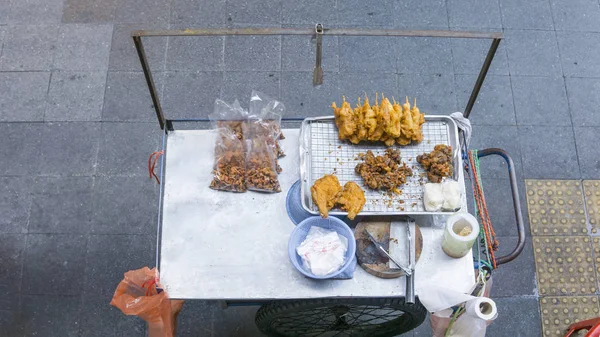 Vista superior de um carrinho de comida de rua tailandesa preparando alimentos com palitos de frango frito e carne de porco com ricen pegajoso cidade de Bangkok, Tailândia — Fotografia de Stock
