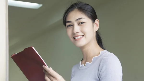 A menina asiática lê um livro vermelho — Fotografia de Stock