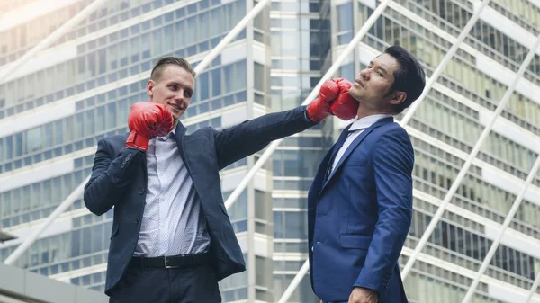Two business mans are fighting with boxing glove at outdoor city — Stock Photo, Image