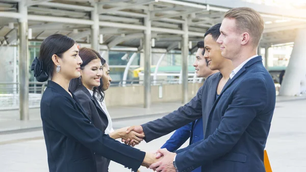 Takım iş insanlar akıllı erkek ve kadın konuşmak ve elini sıkmak 
