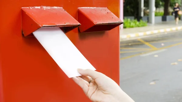 Ręka z pocztówki i spadek postbox czerwony poczty — Zdjęcie stockowe
