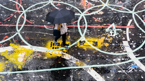 people with umbrella walks on the pedestrian street in the top a