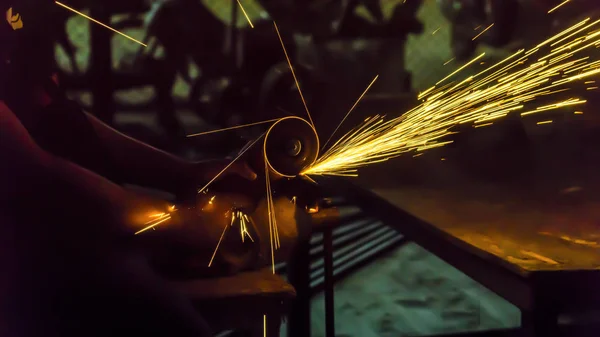 The worker uses cutting machine to cut metal, focus on flash lig — Stock Photo, Image