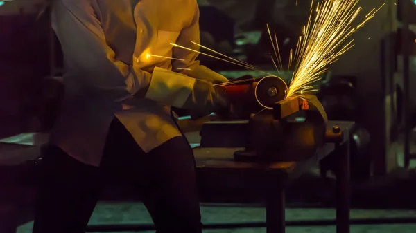 Рабочий использует режущую машину для резки металла, сосредоточиться на вспышке света — стоковое фото