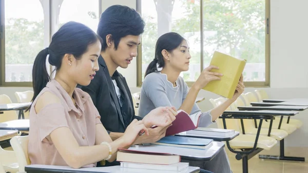 Gente estudiante leer libro y sentarse en sillas de conferencia — Foto de Stock