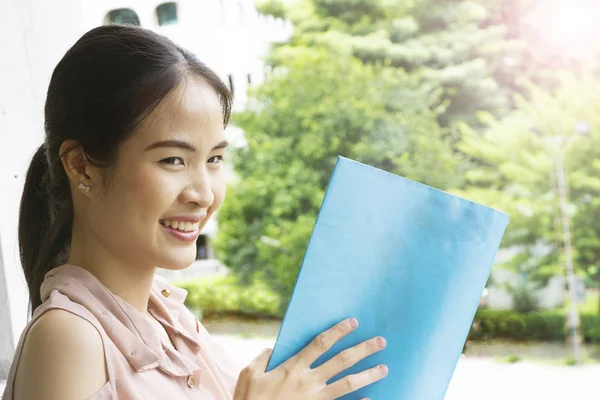 La chica asiática lee un libro azul —  Fotos de Stock