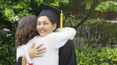 kız öğrenci mezuniyet önlük ve şapka ile sarılmak üst