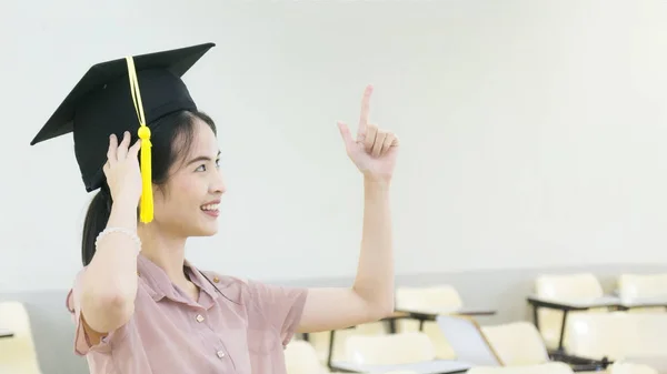 Flicka student med examen hatt i klassrummet — Stockfoto