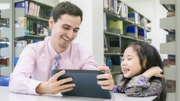 Hombre profesor y niño estudiante aprendizaje y mirando en el dispositivo de tableta — Foto de Stock