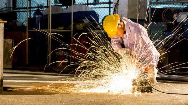 Работник использует шлифовальный разрез металла, сосредоточиться на флэш-световую линию ша
