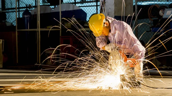 worker uses grinding cut metal, focus on flash light line of sha