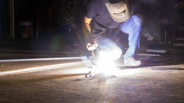 Trabajador de soldadura de metal, se centran en la línea de luz de flash de chispa aguda, en la luz baja — Foto de Stock