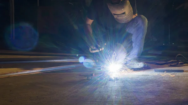 Metal, odak düşük ışıkta keskin kıvılcım birden parlamak ışık satırındaki Kaynak işçisi — Stok fotoğraf
