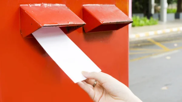 Ręka z pocztówki i spadek postbox czerwony poczty — Zdjęcie stockowe