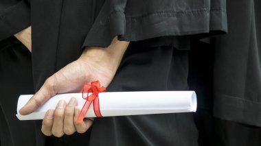 Siyahi mezuniyet elbiseli insanlar diploma taşıyorlar..