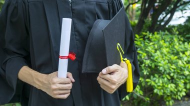 Siyahi mezuniyet elbiseli insanlar diploma taşıyorlar..