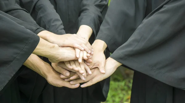 Pessoas com vestidos pretos juntar a mão no agrupamento . — Fotografia de Stock