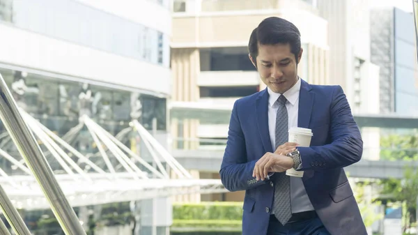 Negocio asia hombre stand con papel taza de bebida al aire libre —  Fotos de Stock