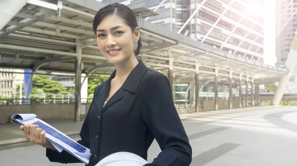 Business kvinna står med säker och konstruktion hjälm — Stockfoto