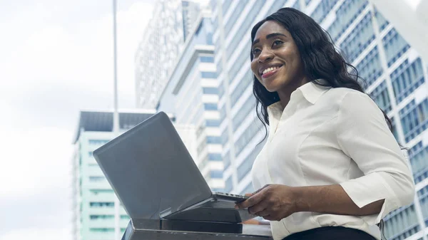 Portrait of happy business african woman uses computer laptop
