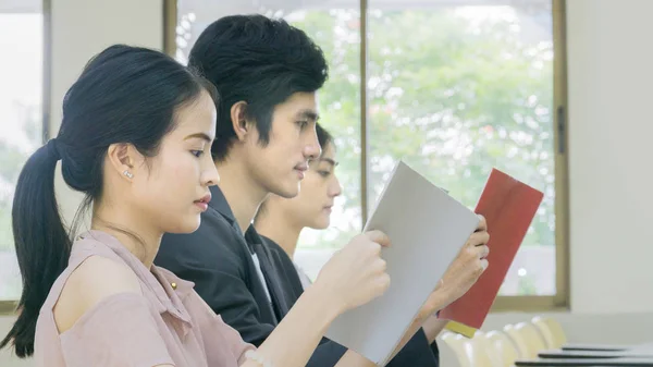 Persone studente leggere il libro e sedersi in cattedre — Foto Stock