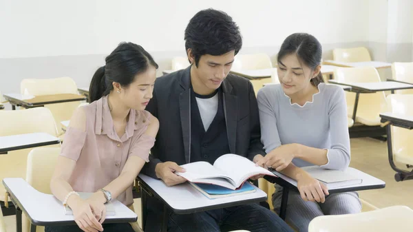 Estudiante de grupo leer libro y sentarse en el aula — Foto de Stock