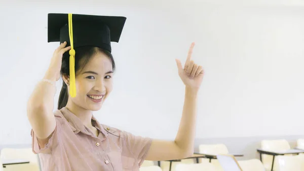 Girl student with the graduation hat in classroom — Stock Photo, Image