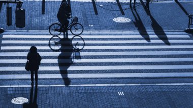 insanlar (üst hava görünümünü yolda karanlık gölge ile akşam günbatımında iş şehir ve adam binmek bisiklet Kavşağı Caddesi yaya yaya geçidi siluet insanları yürü)