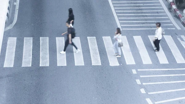 busy blur people walk fast across the sign of crossroad in the c