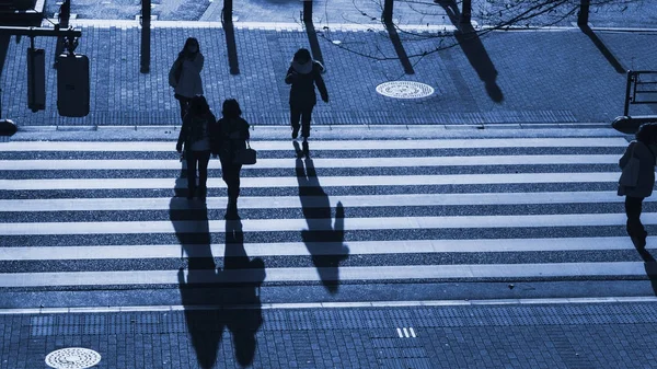 剪影人步行在步行人行横道在商业城市的连接街道在傍晚日落与人的黑暗的阴影在路 顶面空中视图 — 图库照片