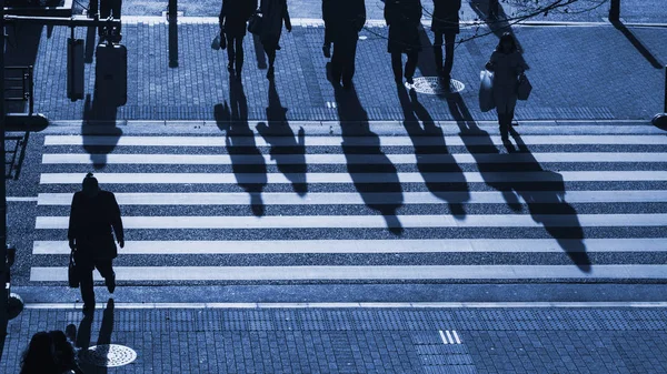 silhouette people walk on pedestrian crosswalk at the junction